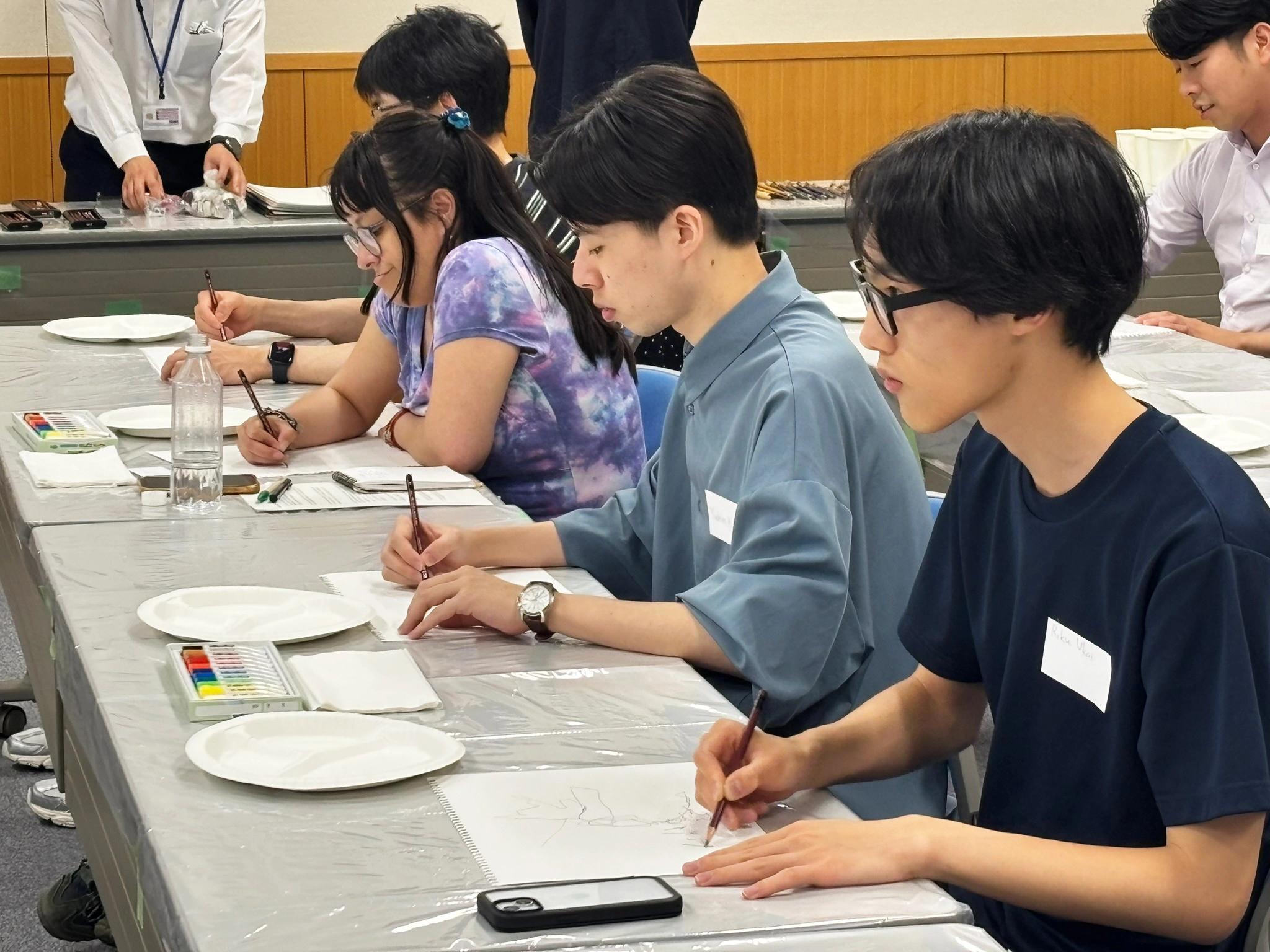 スクリーンの絵を見ながら一筆書きに取り組む参加者